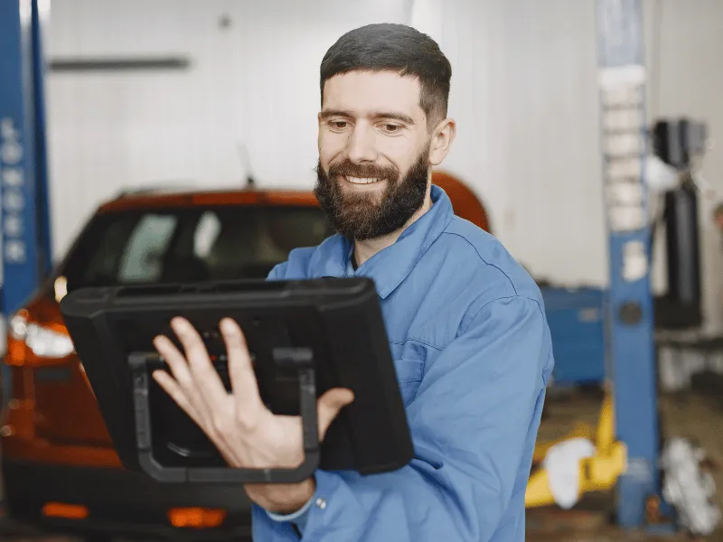 Kfz-Mechaniker plant Werkstatttermine auf einem Tablet